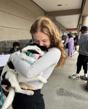 Photo of Maizey Wheeler holding one of adoption dogs.
