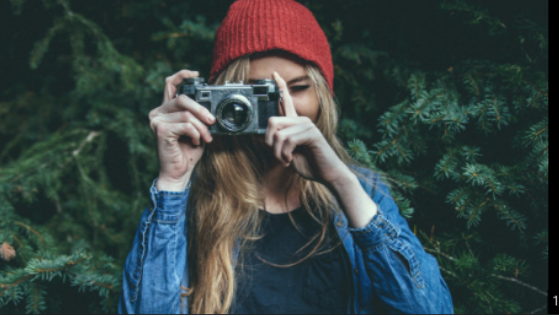 Picture of a woman taking pictures with the focus on the viewer.