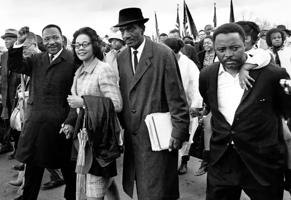 Picture of Dr. Martin Luther King walking with civilians during the Civil Rights Movement.