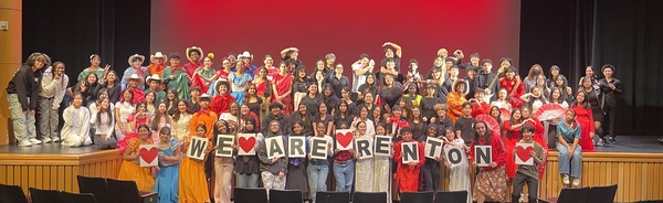 Picture of RHS students participating in our Multicultural Performance Show with a sign stating "We are Renton."