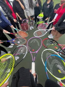 A picture of tennis players' tennis racquets in a group circle.
