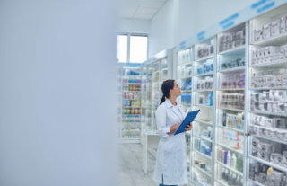 Photo of a Pharmacist looking at medications (https://thehappypharmd.com/retail-pharmacy/).
