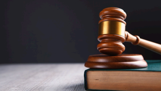 Image of a gavel on a book used by a judge in court.