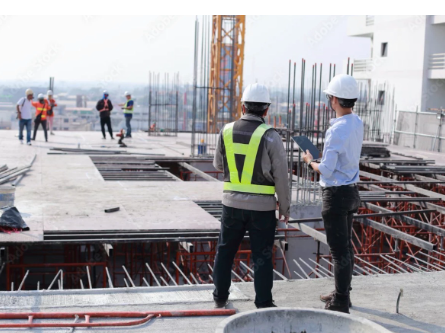 A picture of a construction manager and construction workers at a job site.