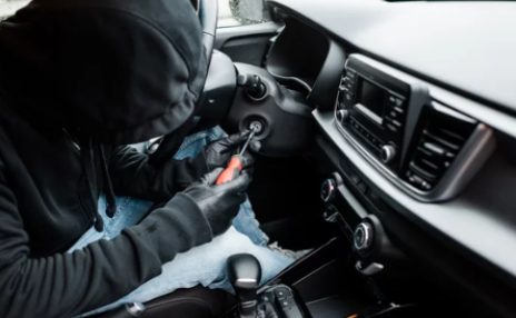 Photo of a person stealing a car.