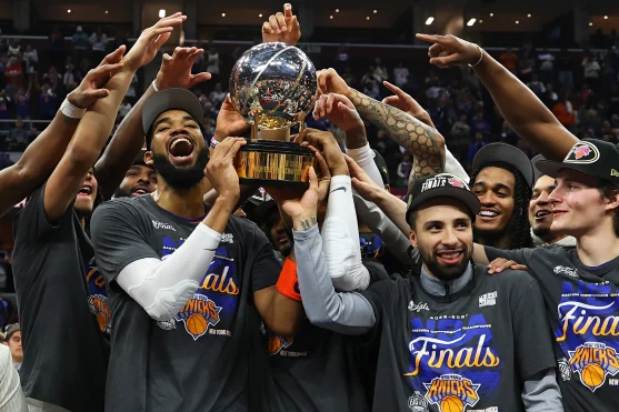 Photo of Knicks players holding the Eastern Conference Finals Trophy after their win.